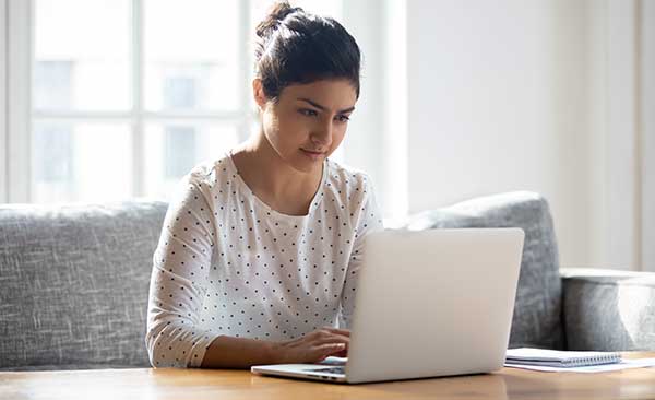 Women completing self refer form on her laptop.