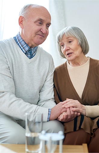 Emotional elderly couple holding hands